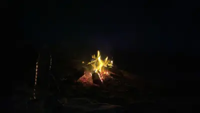 a camp fire on a hill at night at Auberge Tigida in Mhamid
