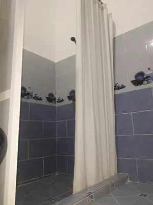 a shower with a white curtain in a bathroom at Hôtel Glacier in Fès