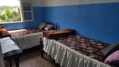 a blue room with two beds and a window at Hôtel Glacier in Fès