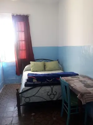 a bedroom with a bed and a table and a window at Hôtel Glacier in Fès