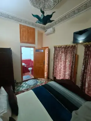 a bedroom with a bed and a door to a bathroom at RIaD DRISSIA Panoramic in Fès