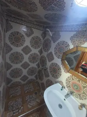 a bathroom with a sink and a tile wall at RIaD DRISSIA Panoramic in Fès