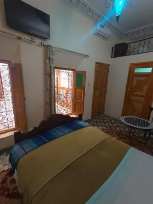 a bedroom with a bed and a tv on the wall at RIaD DRISSIA Panoramic in Fès