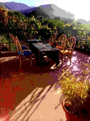 a table and chairs on a patio with a view at Gte Tawada - Haut-atlas - Chambre pour 2 Personnes in Ikhf nʼIghir