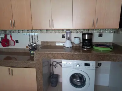 a kitchen with a washing machine under a counter at Appartement abdessalam fetouaki in Moulay Yacoub
