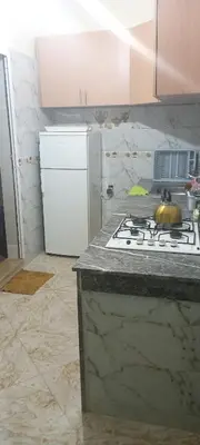 a kitchen with a stove and a white refrigerator at Dar abd essalam in Moulay Yacoub