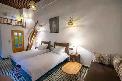 a bedroom with two beds and a couch at Riad Soultana in Fès