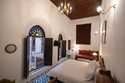 a bedroom with a bed and a window and a chandelier at Riad Soultana in Fès