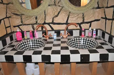 a checkered table with two sinks in a bathroom at Maison Acacias in Erfoud
