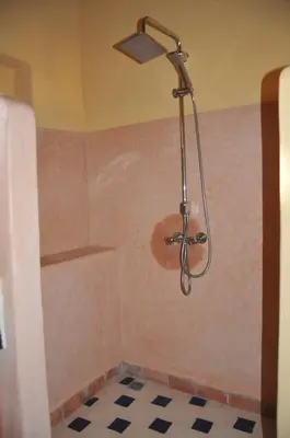 a shower with a shower head in a bathroom at Maison Acacias in Erfoud