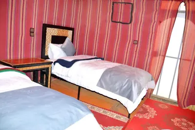 a room with two beds and a mirror at Merzouga cheer camp in Merzouga