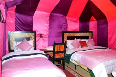 two beds in a pink and purple tent at Merzouga cheer camp in Merzouga
