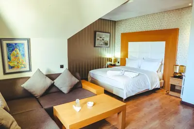 a hotel room with a bed and a couch at Hotel Perce Neige in Ifrane