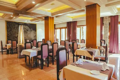 a restaurant with tables and chairs in a room at Hotel Perce Neige in Ifrane