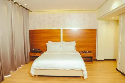 a bedroom with a large bed with white sheets at Hotel Perce Neige in Ifrane