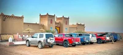 a row of trucks parked in front of a building at Porte De Sahara Ouzina in Ouzina