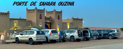 a row of trucks parked in front of a building at Porte De Sahara Ouzina in Ouzina