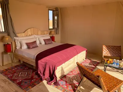 a bedroom with a large bed in a room at THE SANDY TENTS in Merzouga