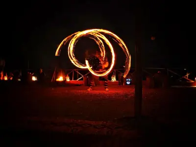 a person is standing in front of a fire object at THE SANDY TENTS in Merzouga