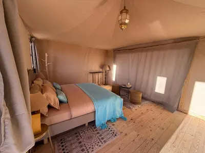 a bedroom with a bed in a tent at THE SANDY TENTS in Merzouga