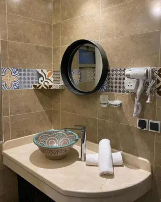 a bathroom sink with a mirror and a bowl at Riad Zyna in Meknès