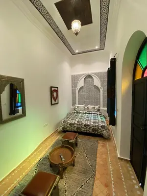 a bedroom with a bed and a table in a room at Riad Zyna in Meknès