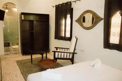 a room with a bed and a mirror on the wall at Riad Zyna in Meknès