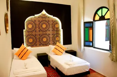 a room with two beds and a window at Riad Zyna in Meknès