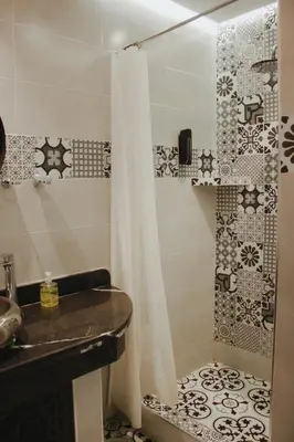 a bathroom with a shower curtain and a sink at Riad Zyna in Meknès