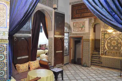 a room with blue curtains and a room with a table at Chez L'habitant Boueden in Fès