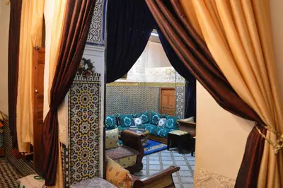 a living room with a couch through a window at Chez L'habitant Boueden in Fès