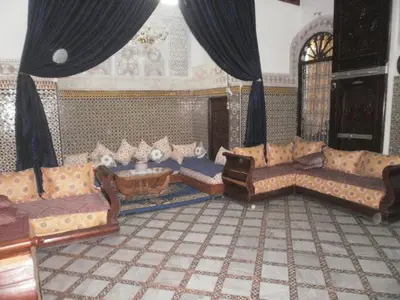 a large living room with couches and a table at Chez L'habitant Boueden in Fès