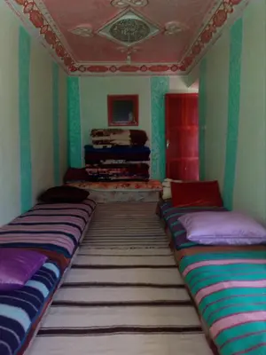 a room with three beds in the corner of a room at Gte Tawada - Haut-atlas - Chambre pour 3 Personnes in Agouti
