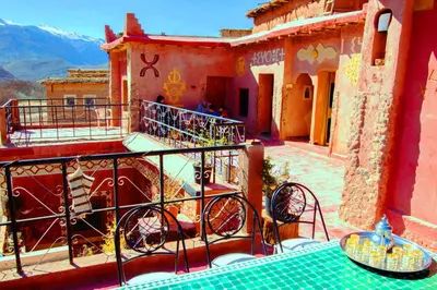 a balcony of a building with a table and chairs at Gte Tawada - Valle Heureuse - Chambre pour 3 Personnes in Agouti