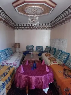 a room with two beds with a table in it at Gte Tawada - Valle Heureuse - Chambre pour 3 Personnes in Agouti