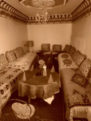 a living room with two beds and a table at Gte Tawada - Haut-atlas - Chambre pour 4 Personnes in Agouti