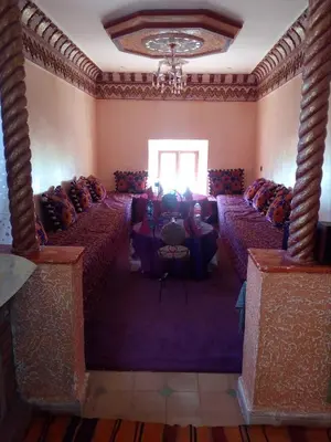 a room with rows of tables and a chandelier at Gte Tawada - Haut-atlas - Chambre pour 4 Personnes in Agouti