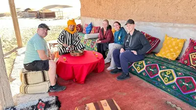 a group of people sitting on a couch at Atta Desert Camp in El Gouera