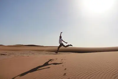 a man running through the desert at Atta Desert Camp in El Gouera