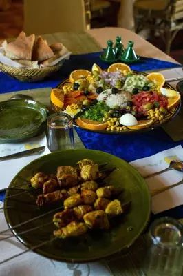 a table with two plates of food on a table at Atta Desert Camp in El Gouera
