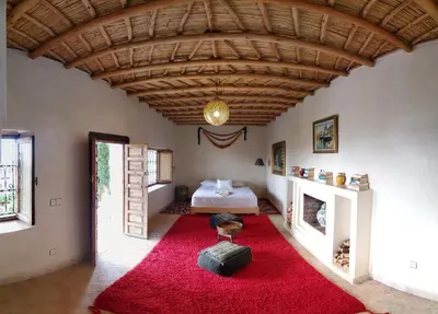 a living room with a red rug and a bed at ourika oufla in Ourika