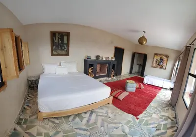 a bedroom with a large bed and a fireplace at ourika oufla in Ourika