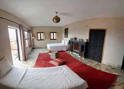 a living room with two beds and a fireplace at ourika oufla in Ourika