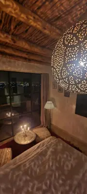 a bedroom with a bed and a large chandelier at ourika oufla in Ourika