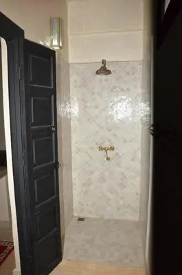 a bathroom with a shower with a tiled floor at ourika oufla in Ourika