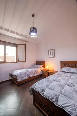 a bedroom with two beds and a pendant light at Chalet Asmoun 2 in Imouzzer Kandar