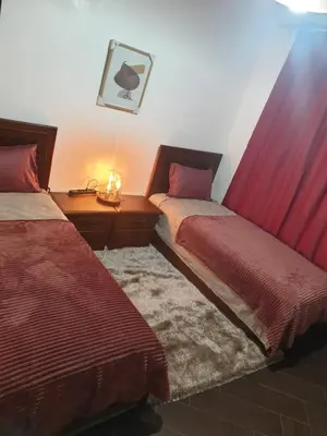 a bedroom with two beds and a table with a lamp at Chalet Asmoun 2 in Imouzzer Kandar