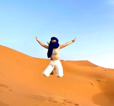 a man is jumping in the desert at NightStars Luxury Camp in Merzouga