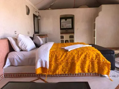 a bedroom with a large bed and a couch at Desert Luxury Camp in Mhamid