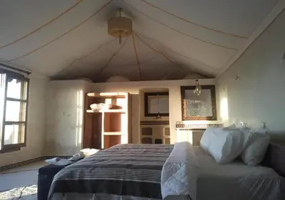 a bedroom with a large bed in a room at Desert Luxury Camp in Mhamid